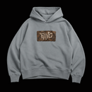 Sudadera color gris de algodón 100%, corte boxy 400gsm, lleva un diseño de fang en el pecho con textura de barro cuarteado.