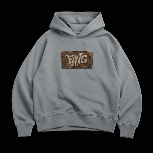 Sudadera color gris de algodón 100%, corte boxy 400gsm, lleva un diseño de fang en el pecho con textura de barro cuarteado.